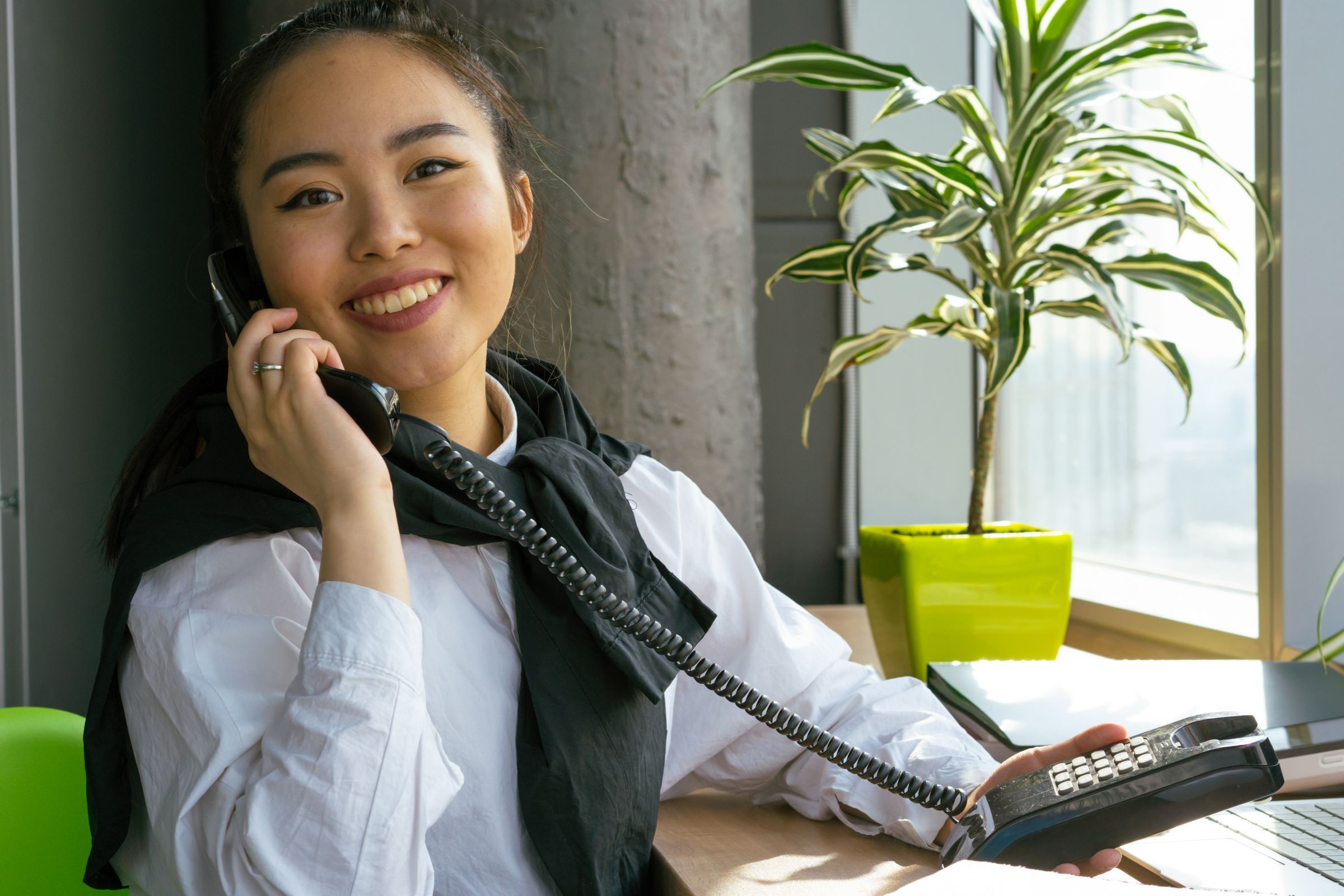An accountant takes a client's call at her desk